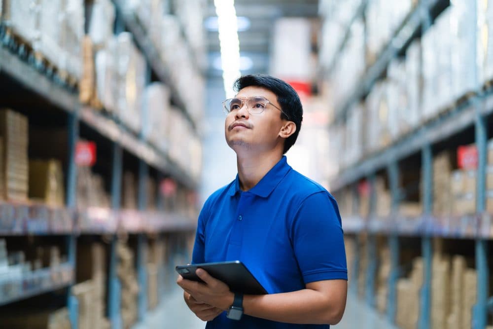 Warehouse operative checking stock levels on a tablet
